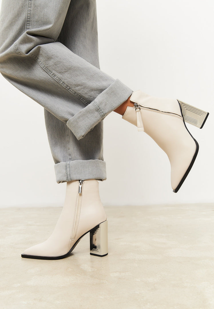 A stylish pair of designer leather ankle boots in classic beige - the perfect addition to any women's footwear collection for a fashion-forward look.