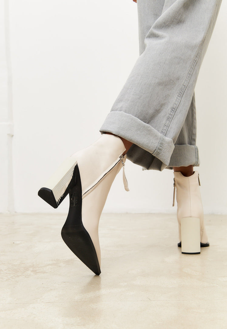 A stylish pair of leather ankle boots, classic beige in color, perfect for women's footwear; these fashion boots are must-have designer ankle boots for your collection.