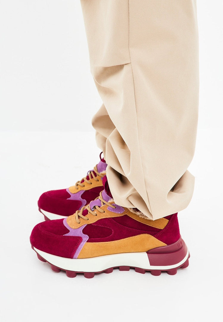 A fashion-forward woman wearing chunky platform Bordeaux sneakers - the ultimate blend of style and comfort in women's platform shoes.