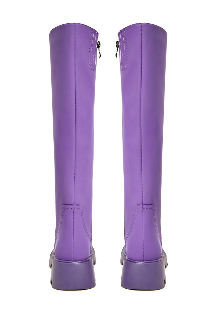 A pair of trendy knee-high chunky sole purple women's fashion boots.