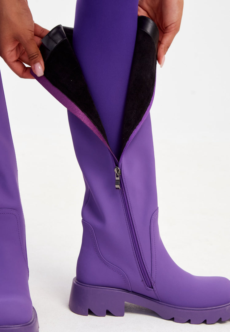 A pair of trendy knee-high chunky sole purple boots for women, stylish fashion boots perfect for any outfit.