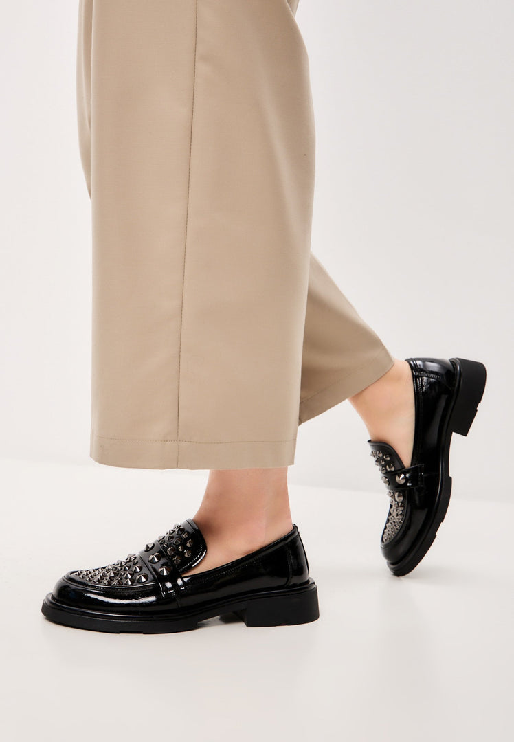 A pair of stylish black leather loafers, perfect for men's fashion footwear, with a rockstar-inspired design.