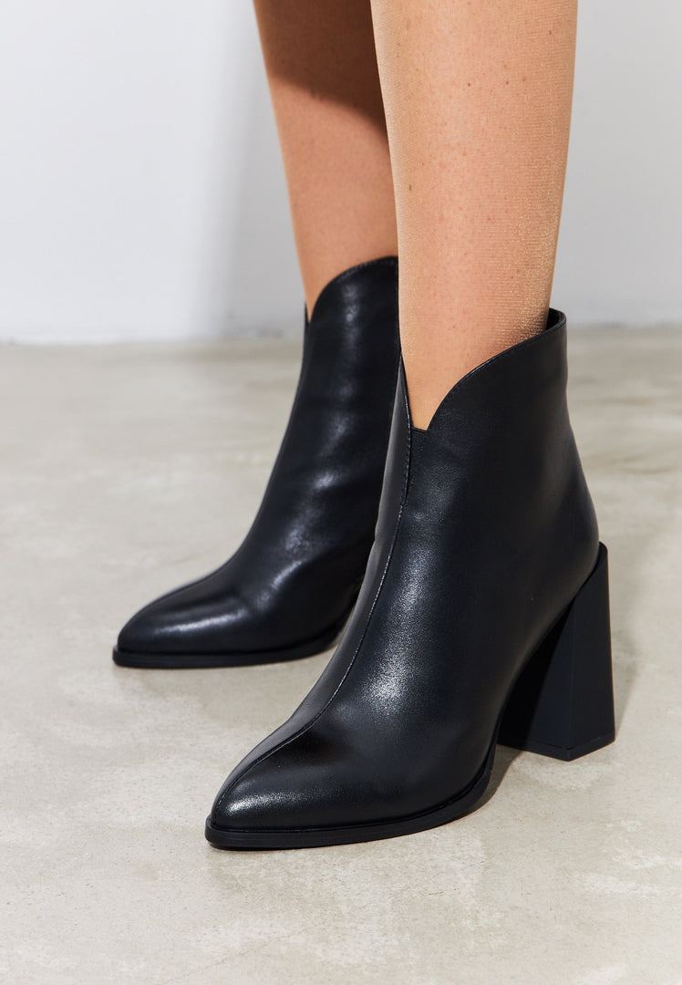 A stylish pair of women's leather ankle boots with a block heel in classic black, perfect for a fashionable and timeless look.