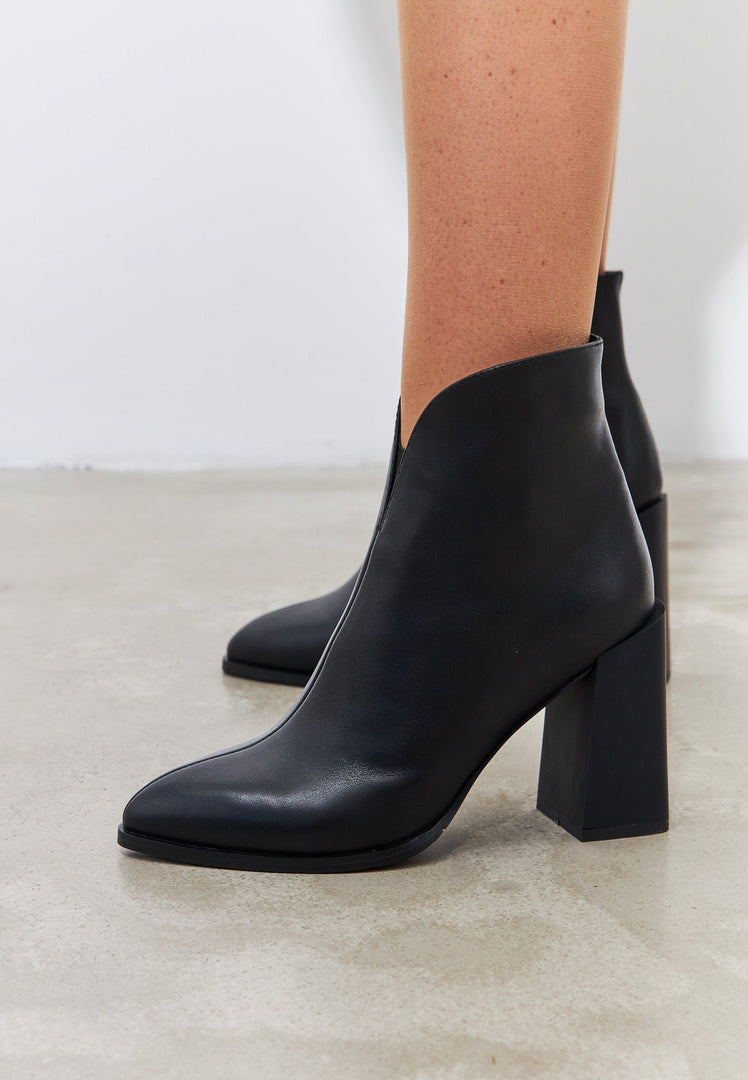 A stylish pair of women's leather ankle boots with a block heel in classic black, perfect for a fashionable look.