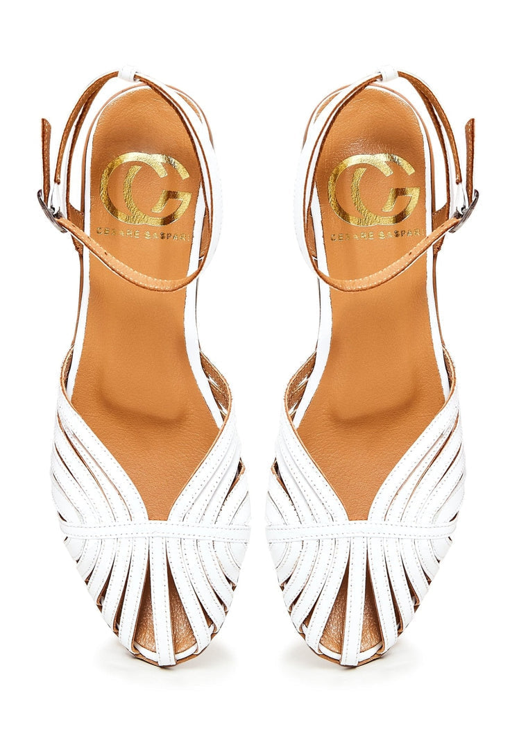 A pair of stylish white leather flat sandals for women, perfect for summer days or a casual stroll.