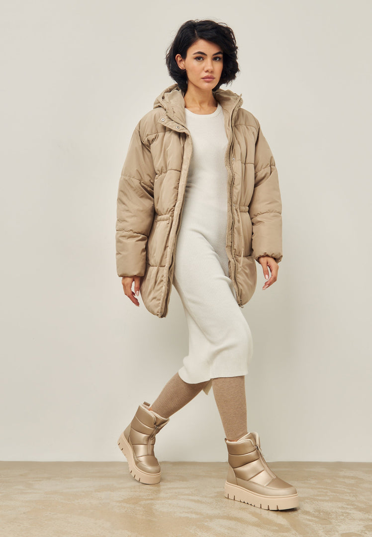 A pair of stylish beige winter boots perfect for snowy days, showcasing elegant and stylish cold weather footwear.