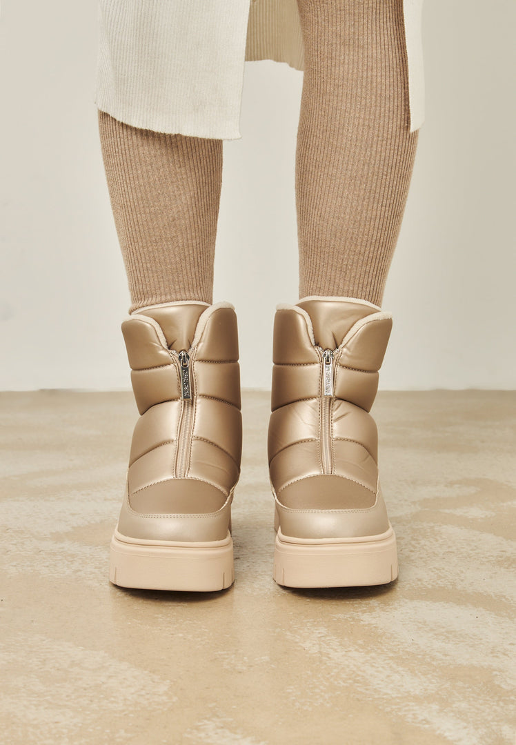Stay chic in the cold with these stylish beige winter boots, a perfect choice for snowy days.