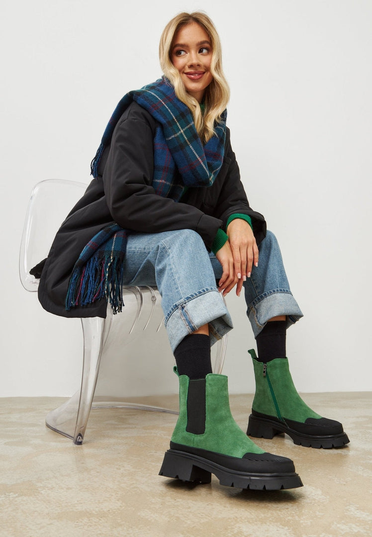 A pair of stylish green ankle boots for women with a platform sole, perfect for urban fashion trends.