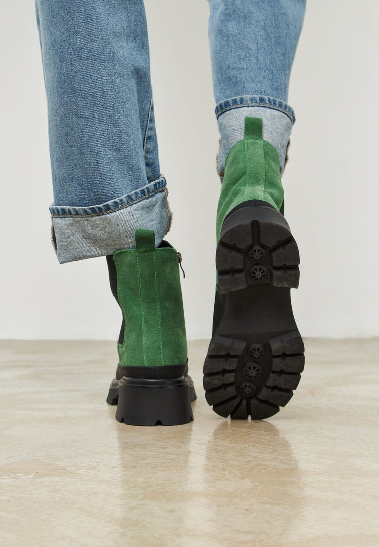 A pair of stylish, fashionable urban platform ankle boots in a trendy green color for women.