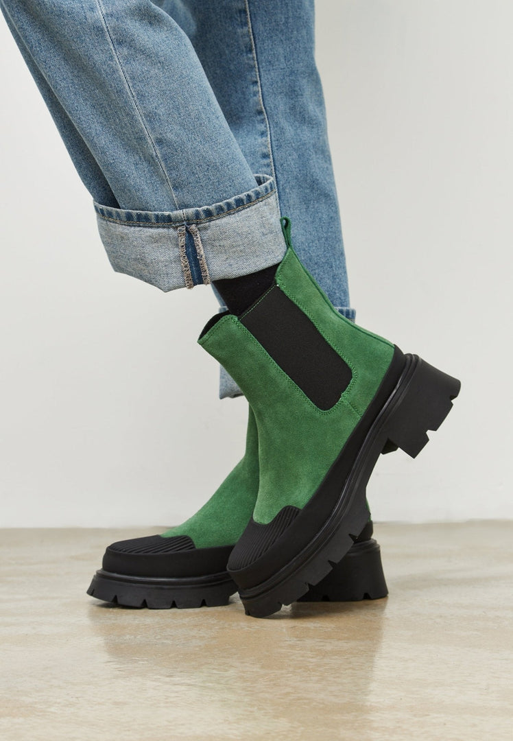 A fashion-forward woman wearing stylish green urban platform ankle boots, perfect for any fashionable urban look.