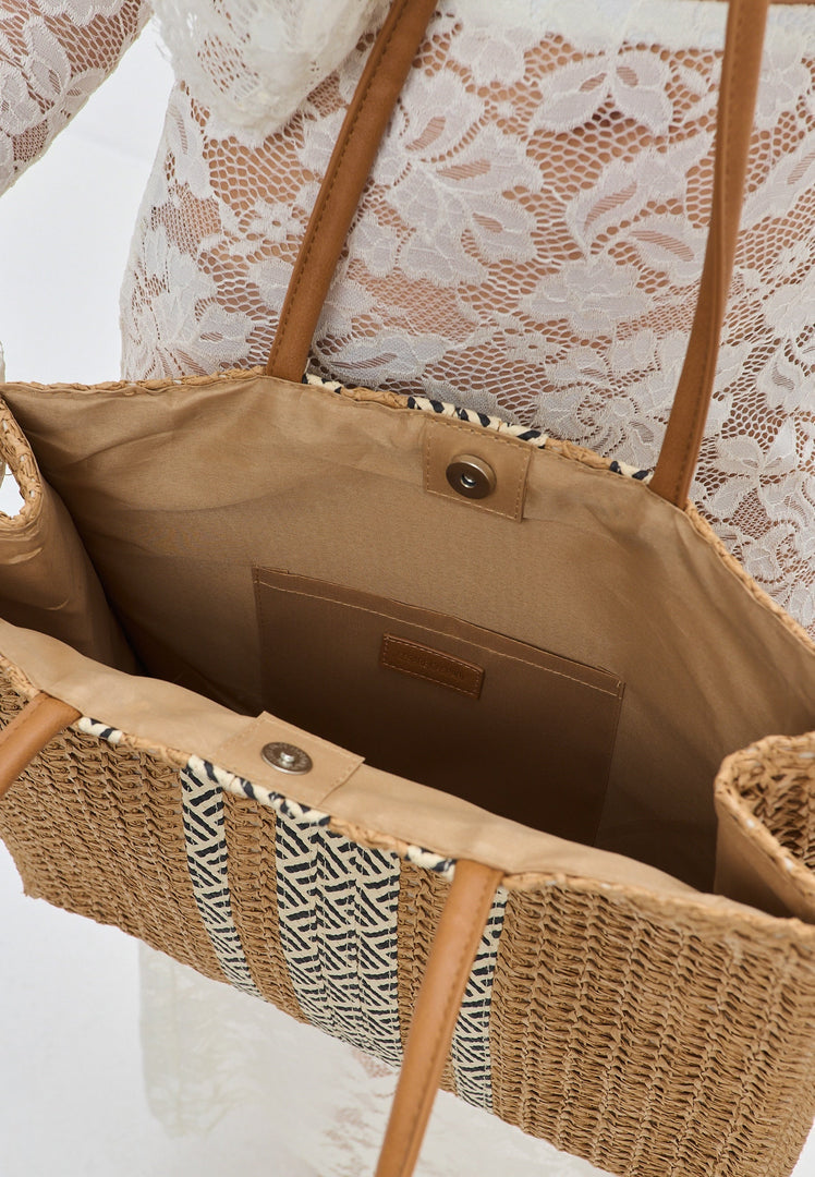 A stylish and practical summer tote bag perfect for the beach, featuring a vibrant striped pattern and sturdy handles.