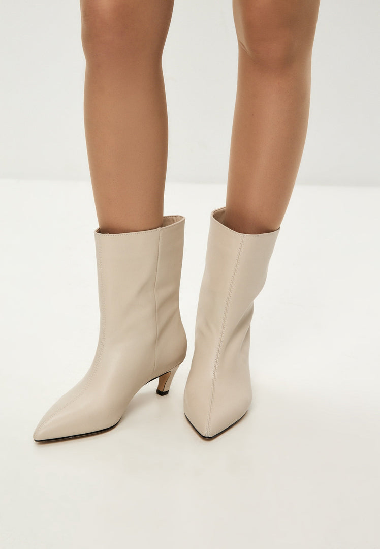 A trendy pair of white kitten heel ankle boots, perfect for fashion-forward women looking for stylish dolly ankle boots.