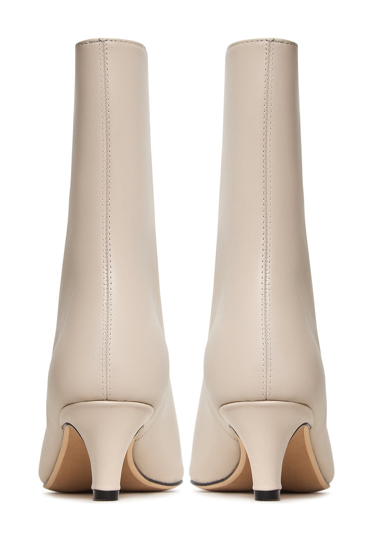 A stylish pair of white dolly kitten heel ankle boots, perfect for trendy women's fashion.