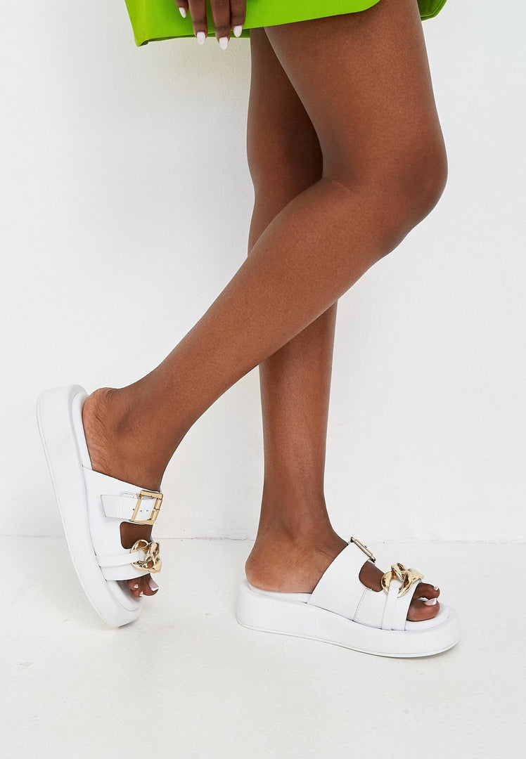A trendy and stylish pair of white leather chain sandals, perfect for women looking for chic summer footwear.