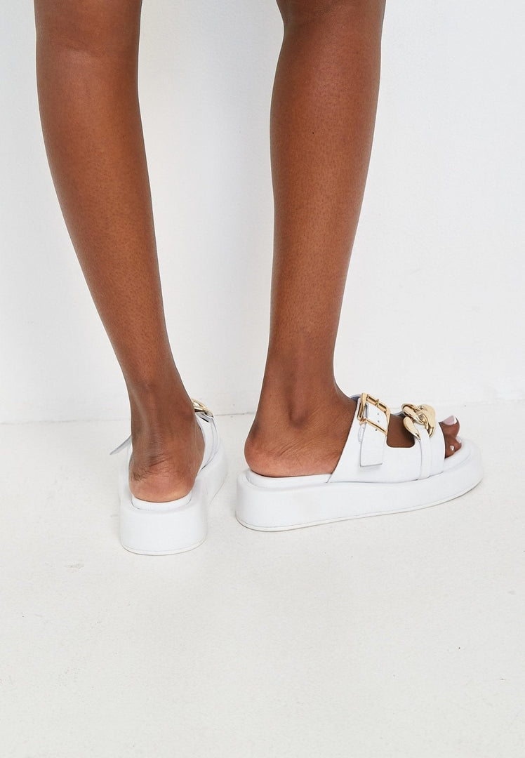 A pair of trendy white leather chain sandals for women, perfect for summer footwear.