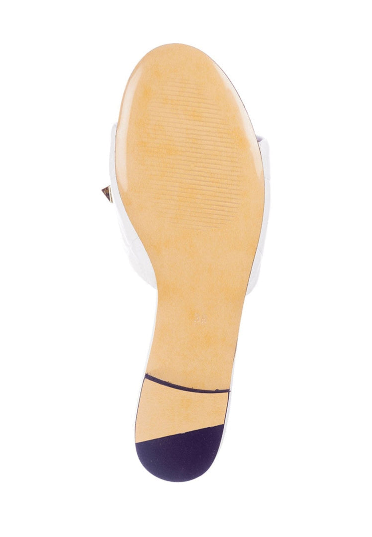 A close-up image of white Rockstud and Mila sandals with stylish studded details.