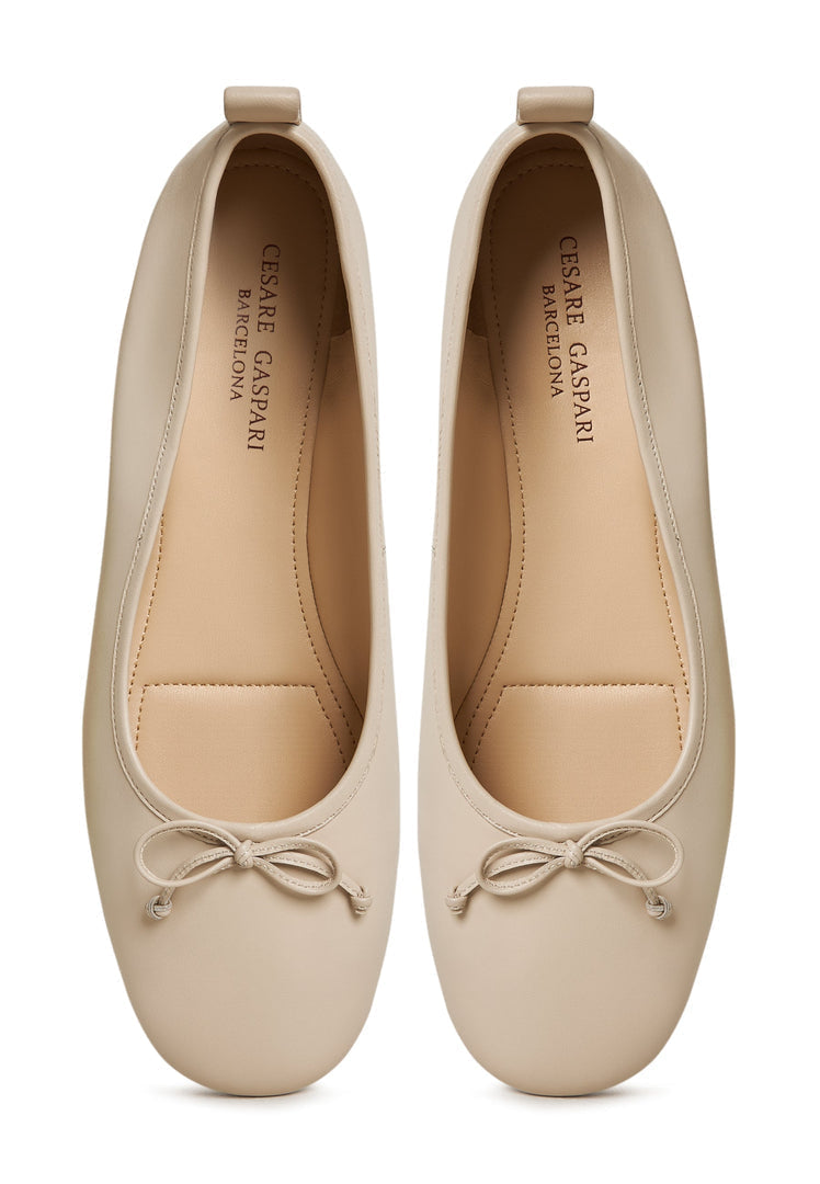 A pair of elegant ivory leather ballerinas - women's leather flats that are perfect as ivory ballet flats, leather slip-on shoes, or ivory dress shoes.
