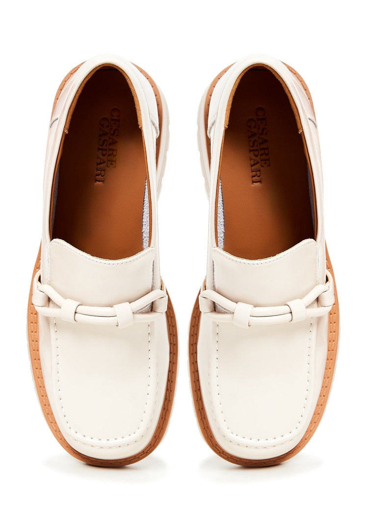 A trendy pair of beige block heels loafers for women, combining fashionable heels with comfortable loafers for a stylish look.