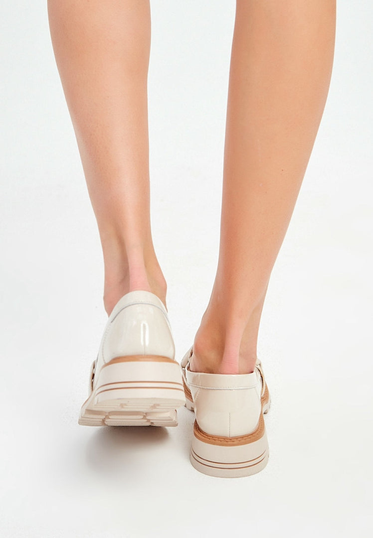A pair of stylish beige block heels loafers for women, a fashionable and comfortable choice in footwear.