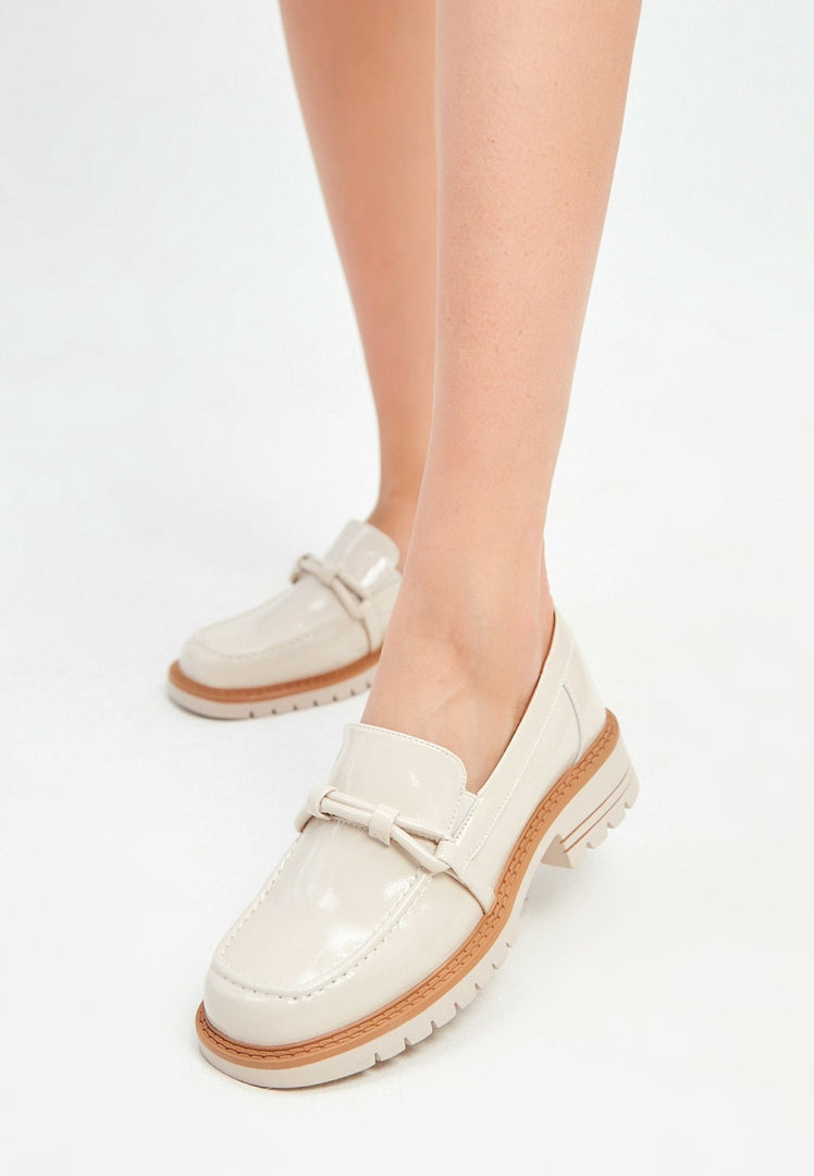 A stylish pair of beige block heels loafers for women, combining fashionable heels with comfortable loafers design.