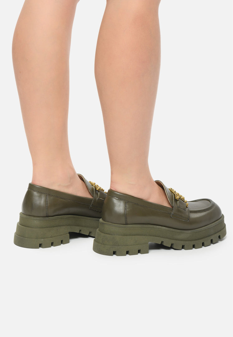 A fashionable pair of women's studded loafers in dark green, showcasing trendy chunky soles for a stylish addition to your fashion footwear collection.