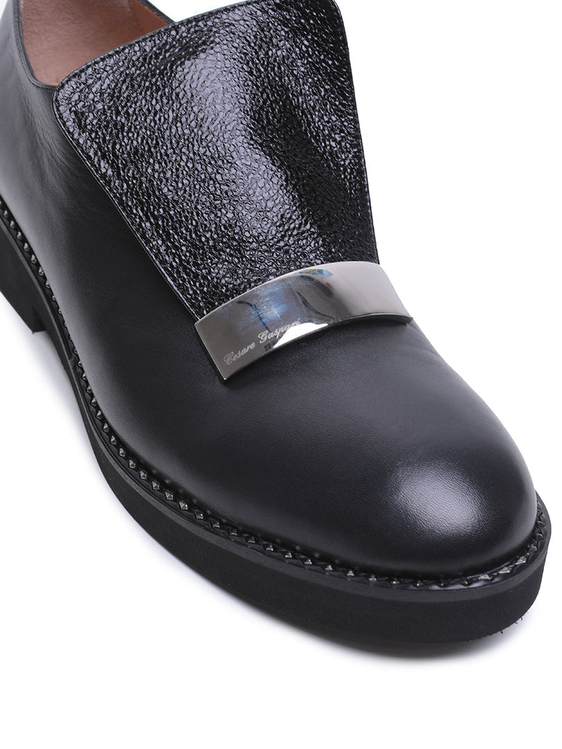 A pair of stylish men's leather slip-on loafers with a sleek metal accent, perfect for a fashionable and polished look.