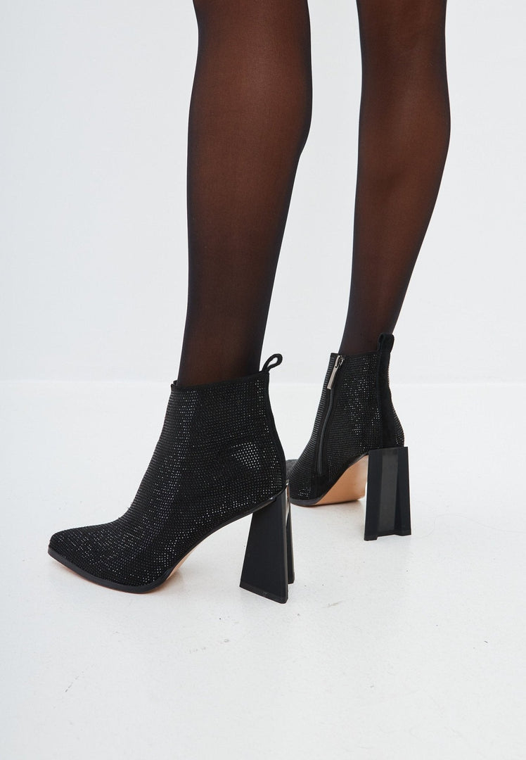 A pair of stylish black suede pointed toe ankle boots with a block heel, perfect leather booties for any outfit.