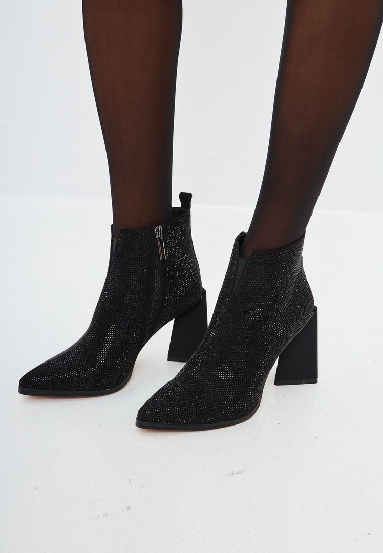 A pair of stylish black suede leather ankle boots with a pointed toe, block heel, and chic design.