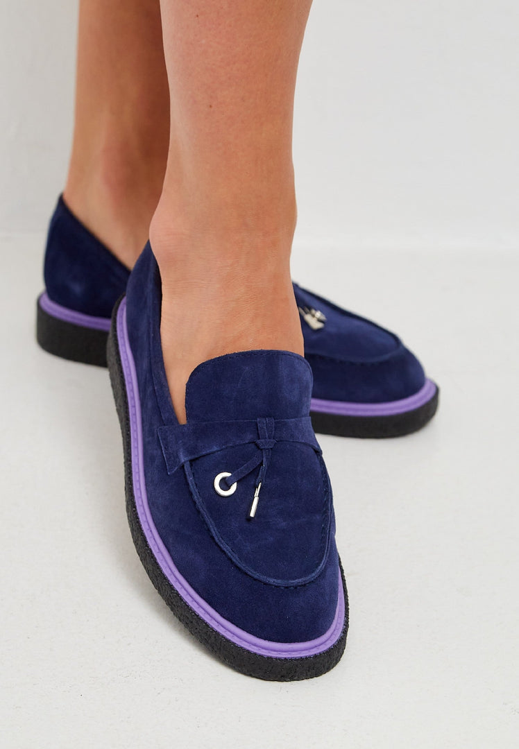A pair of stylish navy blue slip-on suede loafers for men.