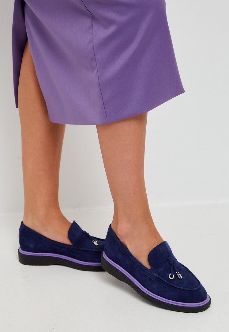 A stylish pair of navy blue suede slip-on loafers for men.