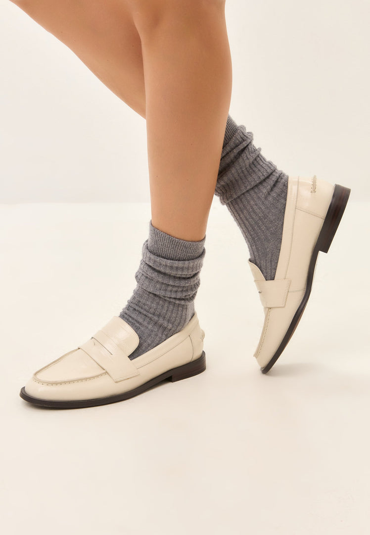 A stylish pair of white leather block heeled loafers, perfect for a fashionable woman's wardrobe.