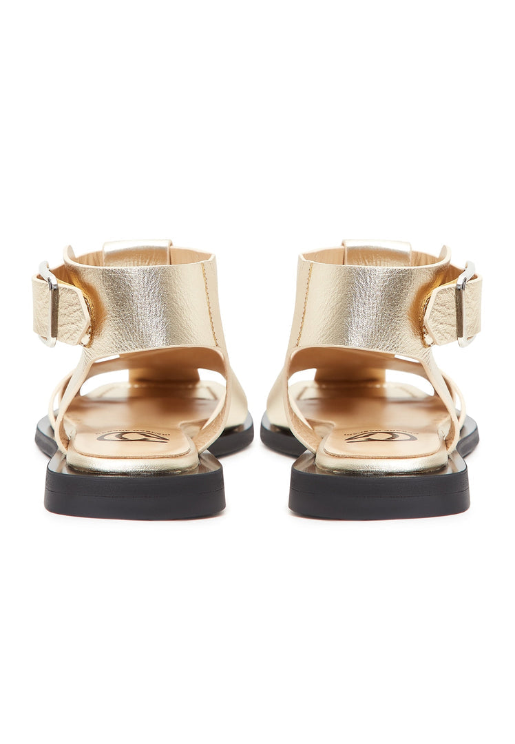 A pair of stylish gold ankle cuff sandals with a flat sole, perfect for women's summer footwear.