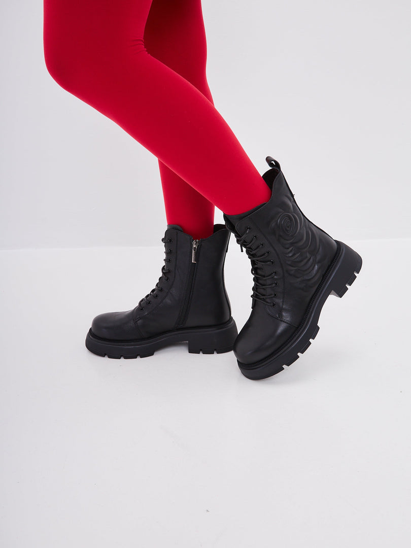 A stylish pair of black leather platform ankle boots for women, with high heels, making them fashionable and trendy.