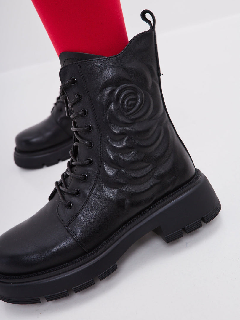 A stylish pair of black leather platform ankle boots for women with high heels, perfect for a fashionable look.