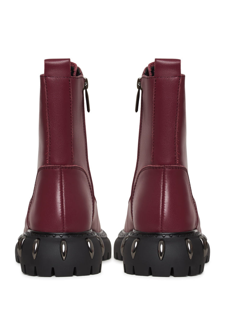 A stylish pair of lace-up combat boots with a chunky sole in a rich bordeaux color, perfect for women's fashion footwear.