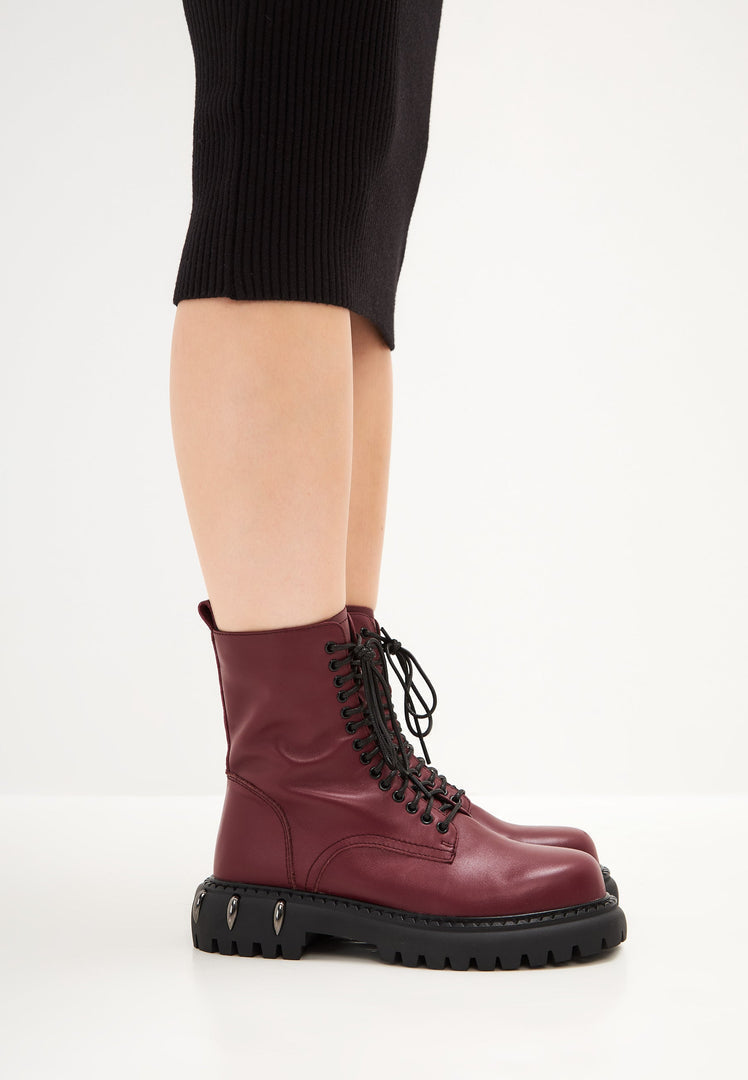 A stylish pair of lace-up combat boots with a chunky sole in Bordeaux, perfect for women's fashion footwear.