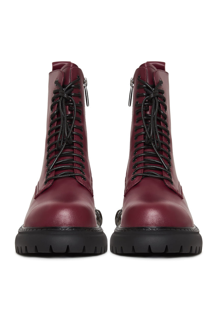 A close-up image of lace-up combat boots with a chunky sole in a trendy bordeaux color, a stylish choice in women's fashion footwear.