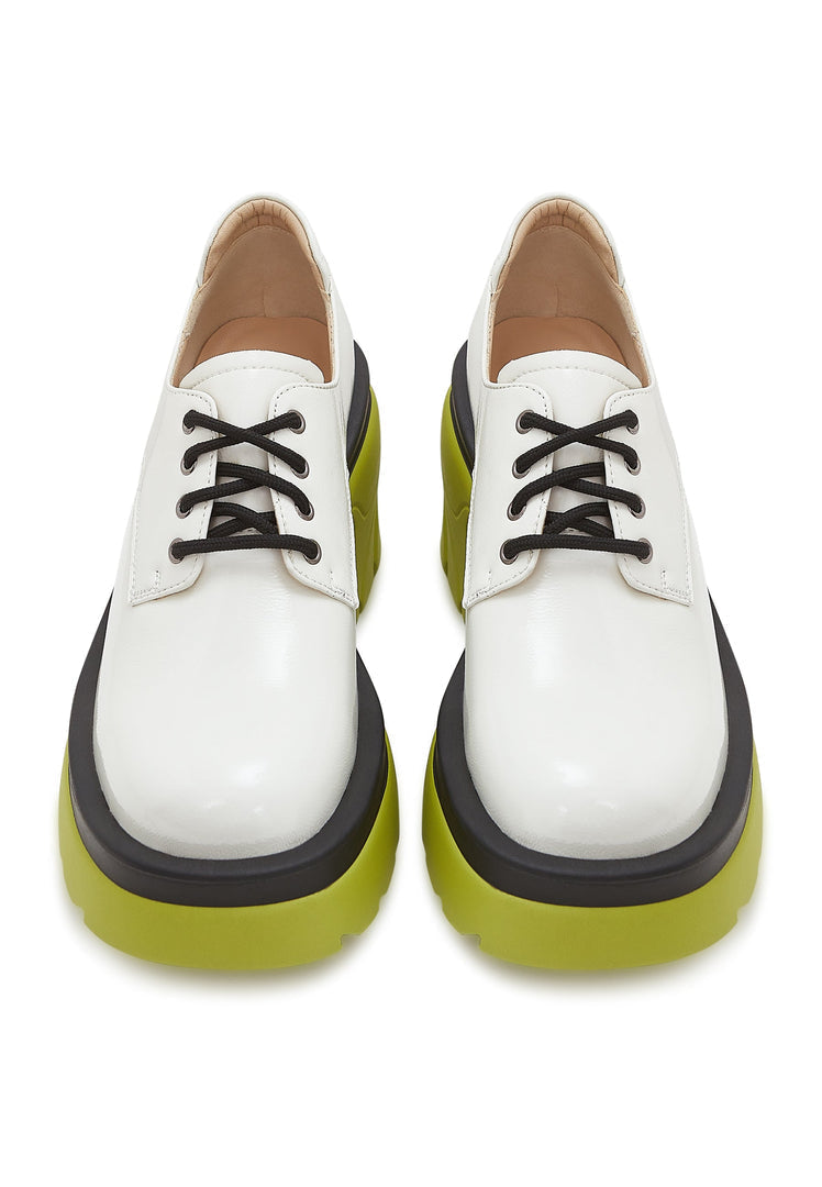A stylish pair of women's fashion oxfords in white featuring a chunky block heel and lace-up design, perfect for making a bold statement.