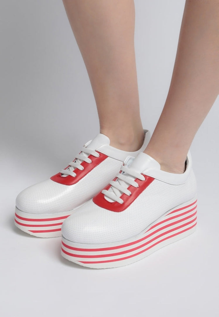 A trendy pair of red high platform sneakers with striped design, ideal for a bold and stylish look.