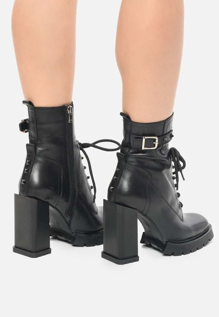 A pair of edgy studded combat boots with a high heel, perfect for a fashion-forward woman looking to make a statement.