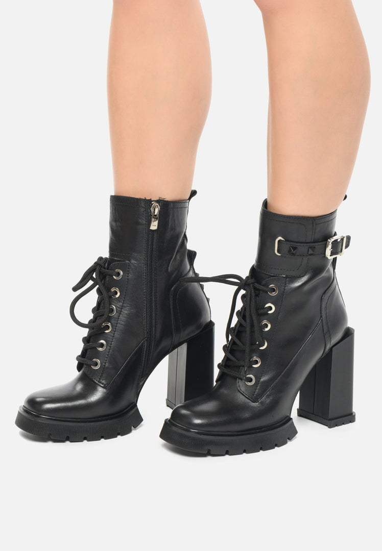 A pair of trendy studded combat boots with a stylish heel, perfect for edgy women's fashion looks.