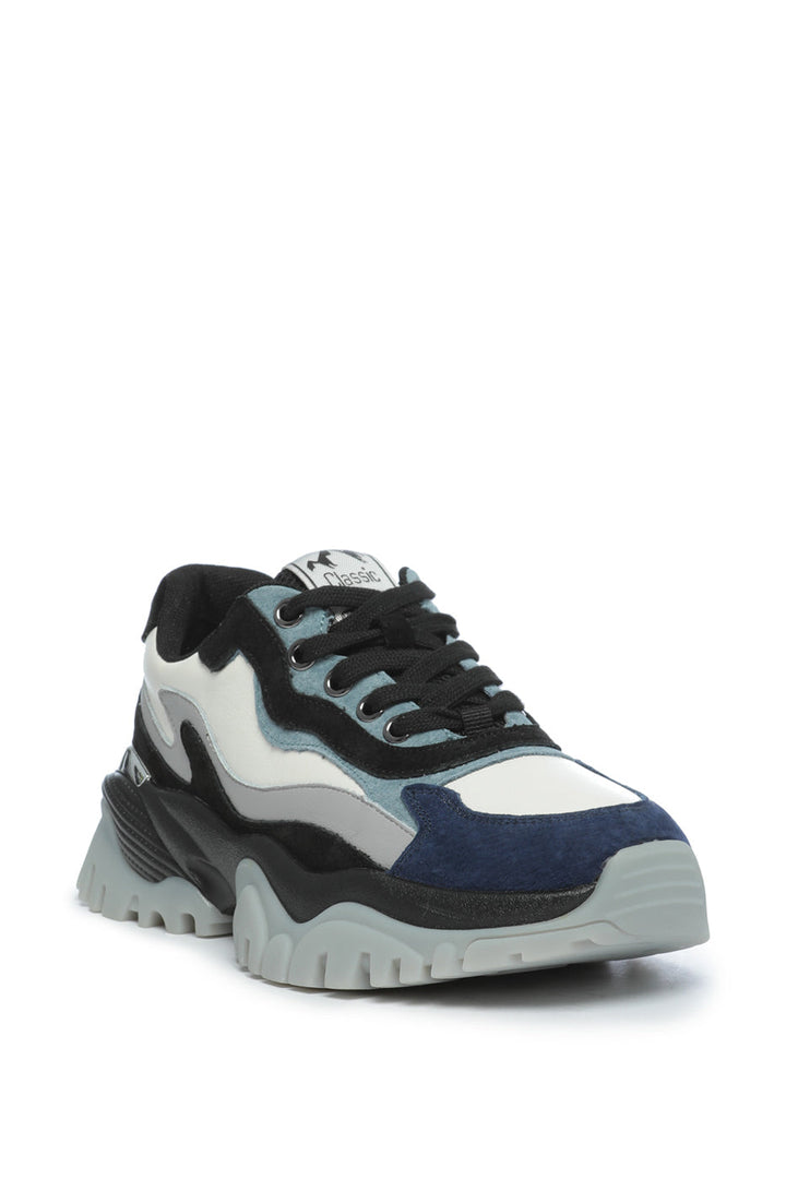 A row of multi-panel, chunky sneakers in various trendy designs, perfect for those looking to make a fashion statement.