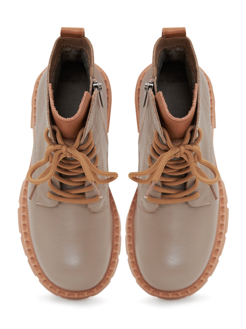 A stylish pair of beige leather lace-up ankle boots for women, perfect for fashion-forward looks.