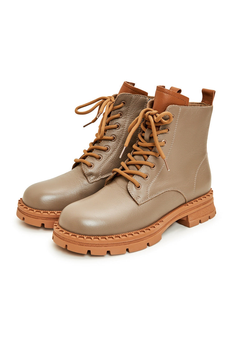 A pair of stylish women's beige leather lace-up ankle boots, perfect for completing any fashion-forward look.