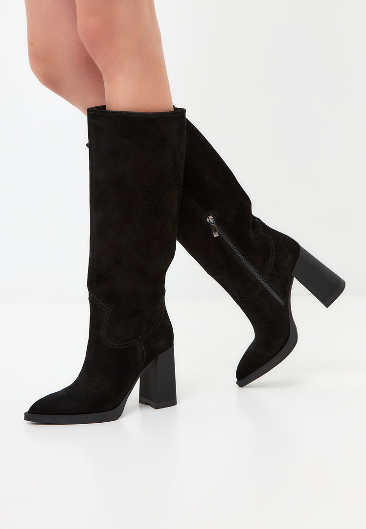 A pair of black knee-high block heel boots, beautifully crafted with elegant detailing, ideal for a chic and sophisticated look. These Bambi boots are a timeless addition to any wardrobe.