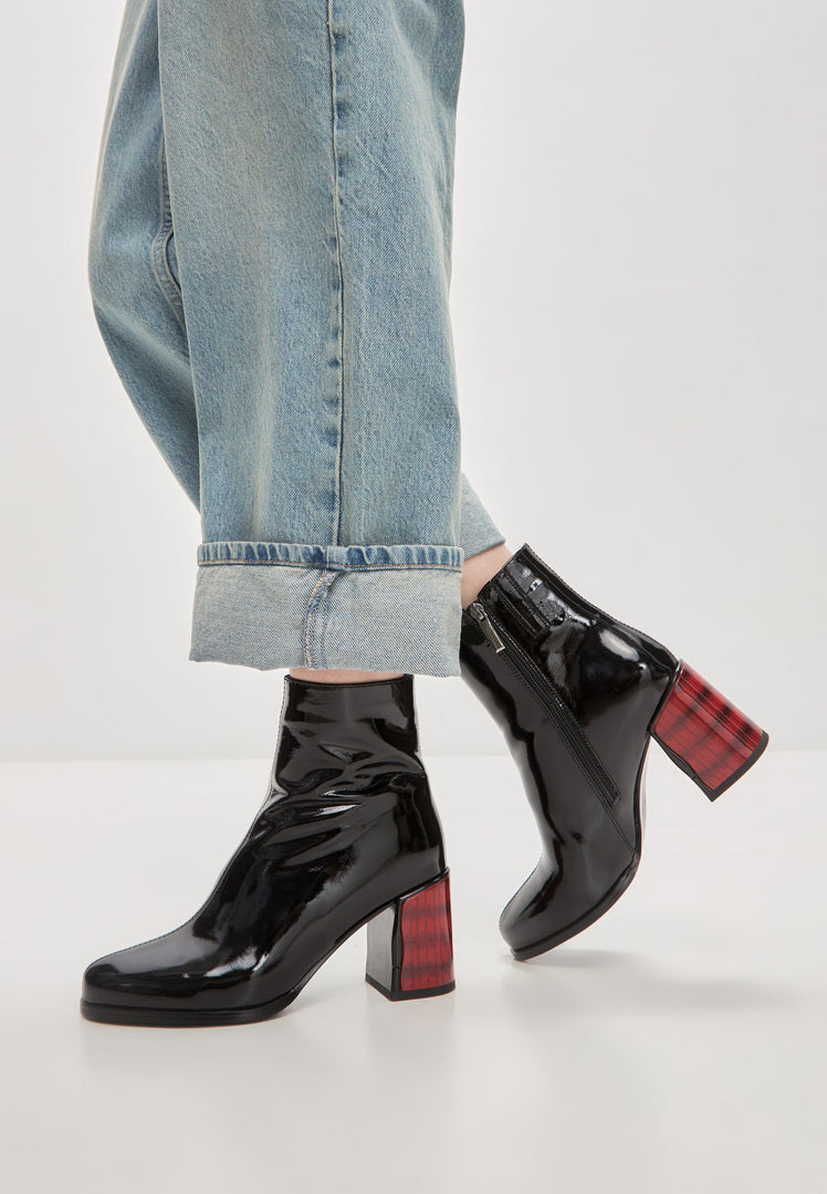 A stylish pair of women's black leather ankle boots with a soft leather heel and patent finish, known as Ella heel boots.