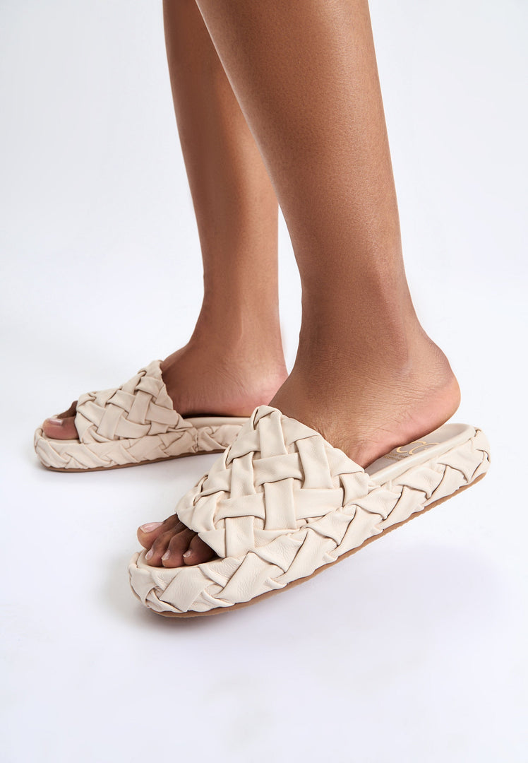 A trendy pair of beige platform slippers, known as Antonella platform sandals, for women looking for stylish and fashionable footwear.