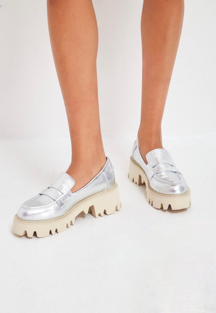 A trendy pair of chunky platform loafers in shimmering silver, perfect for fashion-forward women.