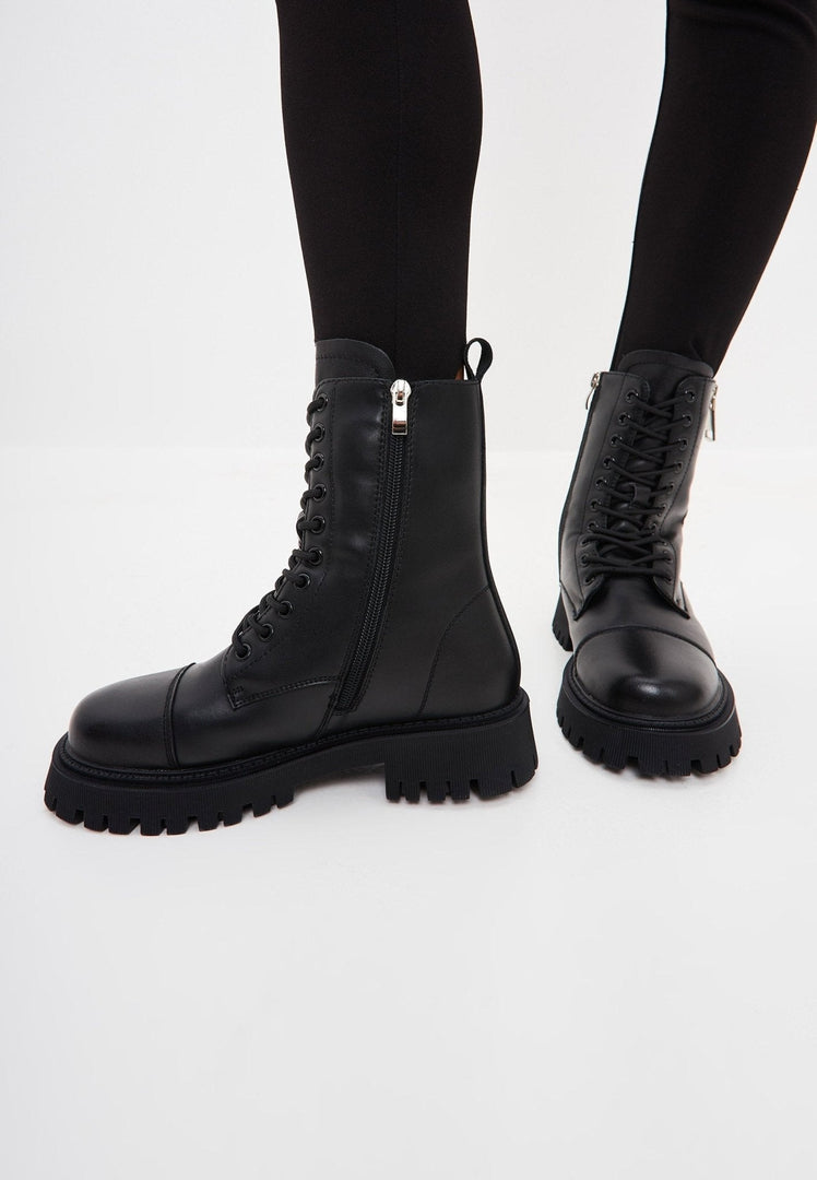 A stylish pair of black leather platform ankle booties, the perfect classic footwear choice for women.
