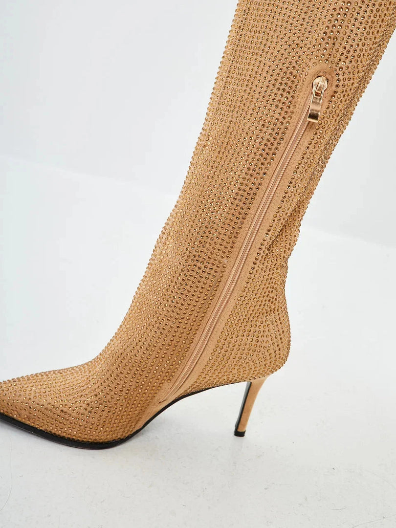 A stylish pair of knee-high gold stiletto boots adorned with jewels, perfect for adding a touch of glamour to your outfit - meet the Mili stiletto boots.